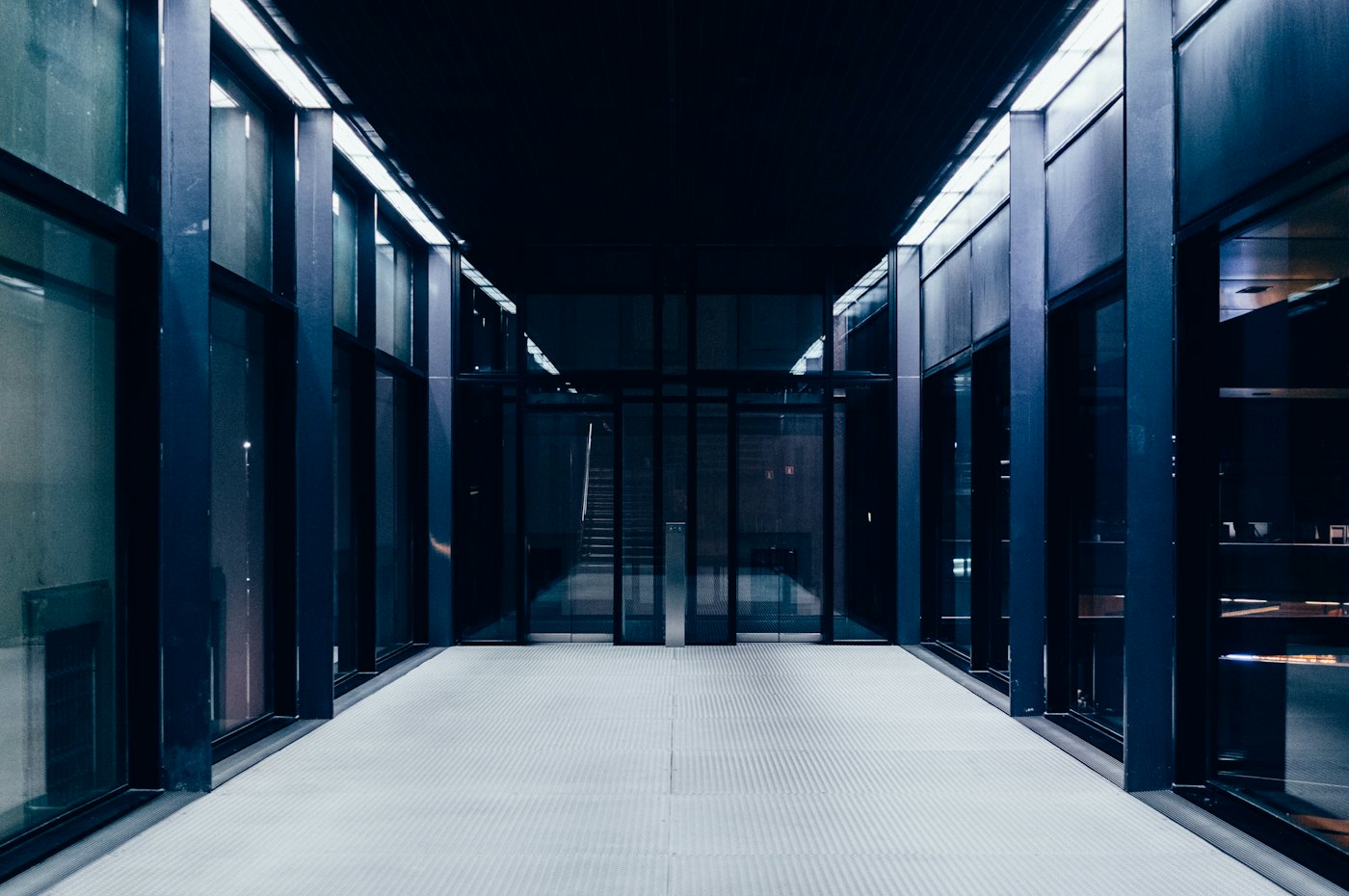 Long data-centre aisle between rows of glass-fronted server racks